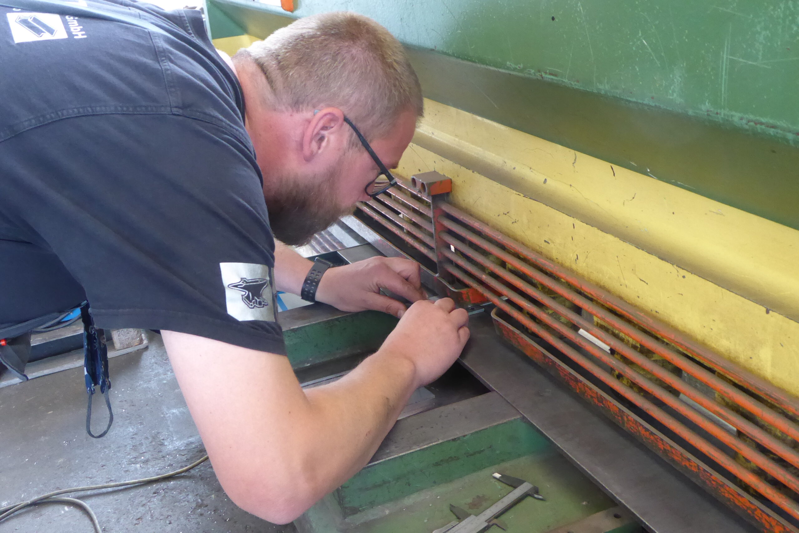 Mitarbeiter der Firma Klenke + Klatt GmbH schneidet Metall an der Kantbank